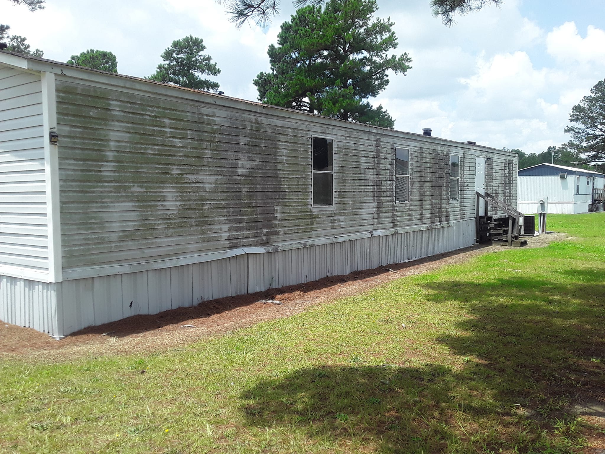 Dirty mobile home exterior before pressure washing
